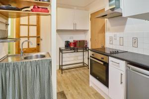 a kitchen with white cabinets and a sink at Host & Stay - The Cabin in Canterbury