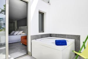 a bathroom with a bath tub next to a bedroom at Barceló Teguise Beach - Adults Only in Costa Teguise