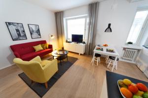 a living room with a red couch and a table at Forenom Serviced Apartments Helsinki Kruununhaka in Helsinki