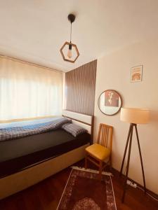 a bedroom with a bed and a chair and a lamp at Sea View Apartment in Kadikoy in Istanbul