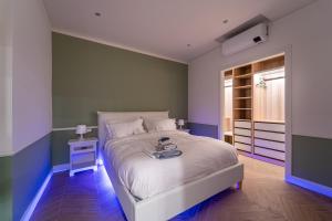 a bedroom with a white bed with a nightstand and a window at Duomo Guest House in Monza