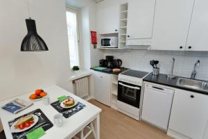 a kitchen with white appliances and a white counter top at Forenom Serviced Apartments Helsinki Kruununhaka in Helsinki