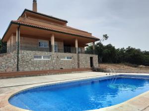 a villa with a swimming pool in front of a house at Shivanda, Habitaciones en Centro de Bienestar en la Naturaleza in Pioz
