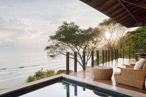 a swimming pool with a view of the ocean at Mukul Resort in Tola