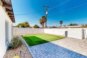 een achtertuin met een kunstmatig gazon voor een hek bij Lone Palm Terrace in Scottsdale