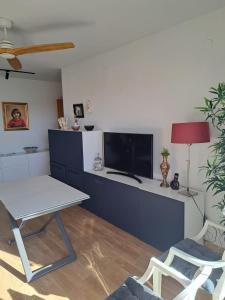 a living room with a table and a tv at Gran apartamento familiar in Granada