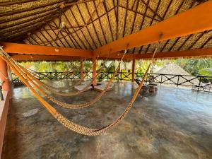 a large room with a hammock in a resort at One Love Hostal Puerto Escondido in Puerto Escondido