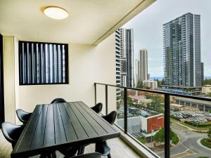 a balcony with a table and chairs and a view of a city at Broadbeach on the park 2-Bedroom in Gold Coast