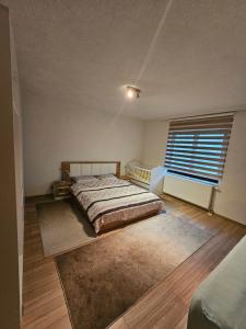 a bedroom with a bed and a large window at Dardania-Home in Prizren