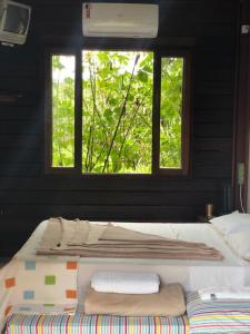 uma cama grande num quarto com uma janela em Pousada Arara Canindé em São Jorge