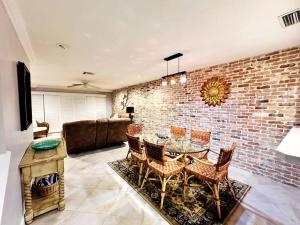 a living room with a brick wall and a table and chairs at Deerfield Beach - Paradise in Deerfield Beach