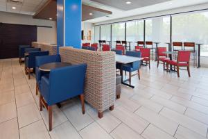 - une salle à manger avec des tables, des chaises et des fenêtres dans l'établissement Holiday Inn Express Los Angeles LAX Airport, an IHG Hotel, à Los Angeles