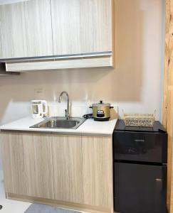 a kitchen with a sink and a stove at Dreamy Aesthetic Suite in City Center in Cebu City