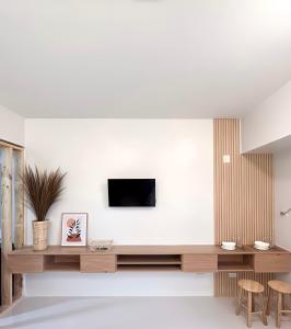 a living room with a tv on a white wall at Dreamy Aesthetic Suite in City Center in Cebu City