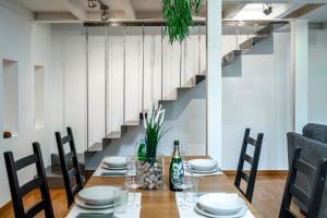 uma sala de jantar com uma mesa e cadeiras e uma escadaria em LuxAvocadoLoft DUOMO 10m em Milão