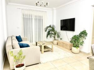 a living room with a couch and potted plants at Madinaty Comfort Residence in Madinaty