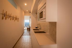a kitchen with white cabinets and a tile floor at The Wave Apartment in Aduanas