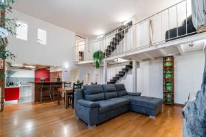 a living room with a couch and a staircase at LuxAvocadoLoft DUOMO 10m in Milan