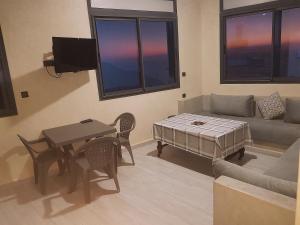 a living room with a couch and a table at Amouage résidence 1 in Sidi Ifni