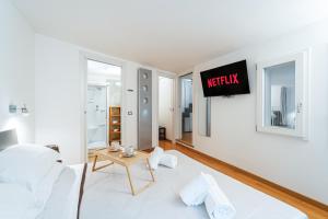 ein Schlafzimmer mit einem Bett und einem TV an der Wand in der Unterkunft LuxAvocadoLoft DUOMO 10m in Mailand