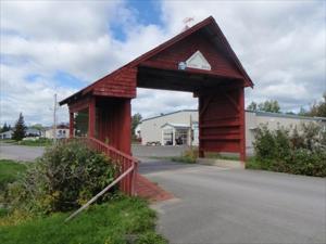 a red covered bridge in a parking lot at Nature's Retreat in Latchford