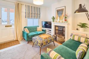 uma sala de estar com mobiliário verde e uma lareira em Host & Stay - Sparrows Nest em Whitstable