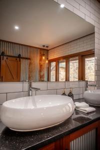 Angaston的住宿－Angaston Saleyards Luxury Accommodation，浴室配有大型白色浴缸和2个盥洗池