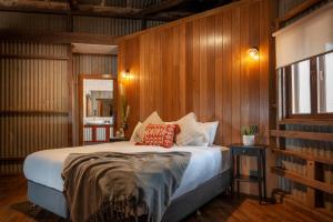 a bedroom with a large bed with wooden walls at Angaston Saleyards Luxury Accommodation in Angaston