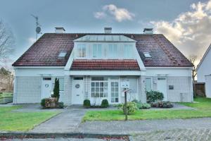 une maison blanche avec un toit rouge dans l'établissement Haus am Seehof 6 Seehof, à Sierksdorf