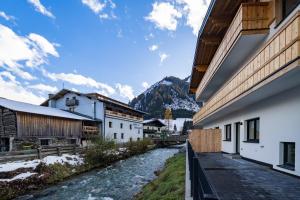 a street in a town with a river between buildings at RIVERSIDE RAURIS APARTMENTS in Rauris