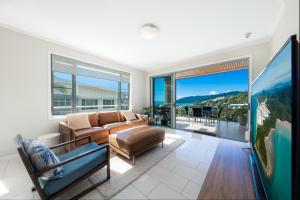 a living room with a couch and a large window at 30 Airlie Beach Bliss at The Summit in Airlie Beach