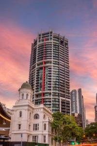 un bâtiment blanc avec un grand bâtiment en arrière-plan dans l'établissement Oaks Brisbane on Felix Suites, à Brisbane