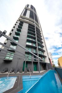 ein hohes Gebäude mit Pool davor in der Unterkunft Oaks Brisbane on Felix Suites in Brisbane