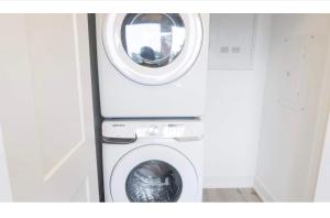 a washer and dryer with a washing machine in a room at Luxury Suite 4mins To Falls in Niagara Falls