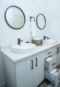 a bathroom with two sinks and two mirrors at Nature's Retreat in Latchford