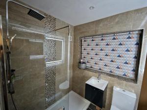een badkamer met een douche, een toilet en een wastafel bij Shirley's Place in Boston Spa