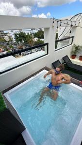 a man in a swimming pool on a house at Studio 27 in Santo Domingo