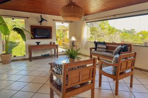 sala de estar con mesa, sillas y TV en Pousada MAR João Fernandes en Búzios