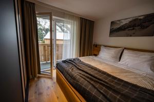 a bedroom with a bed and a large window at RIVERSIDE RAURIS APARTMENTS in Rauris