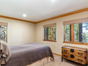 a bedroom with a bed and two windows at Tahoe Pines, enjoy the outdoors this home has to offers in Incline Village