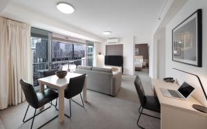 a living room with a couch and a table with a laptop at Oaks Brisbane on Felix Suites in Brisbane