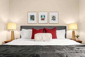 um quarto com uma cama grande e almofadas vermelhas em New Cozy Lower Flat in Roseville em Roseville