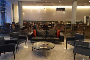 una sala de espera con sofás y mesas en un restaurante en Hotel BA Abasto en Buenos Aires