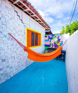 an orange hammock on the side of a building at FLAT DA DANI Galinhos RN in Galinhos