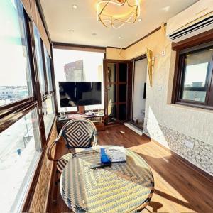 uma sala de estar com uma mesa e uma grande janela em منتجع اووه يامال البحري في الخيران OOh Yaa Mal em Al Khiran