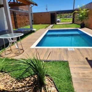 a swimming pool in a yard with a table and a table at Linda Edícula com 2 Dormitórios in Piracicaba