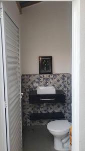La salle de bains est pourvue d'un lavabo et de toilettes. dans l'établissement Linda Edícula com 2 Dormitórios, à Piracicaba