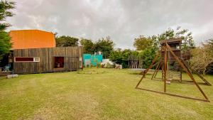 une maison avec une aire de jeux dans une cour dans l'établissement Casa Almeria, à Santa Clara del Mar