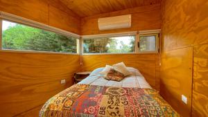 een bed in een kleine kamer met 2 ramen bij Casa Almeria in Santa Clara del Mar