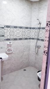 een badkamer met een douche en een toilet bij Amouage résidence in Sidi Ifni